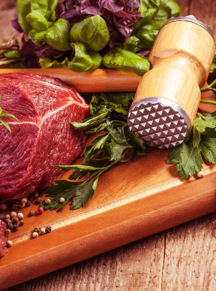 Raw meat on board with herbs — Stock Photo, Image
