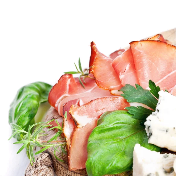 Sliced prosciutto with salami, cheese and basil — Stock Photo, Image