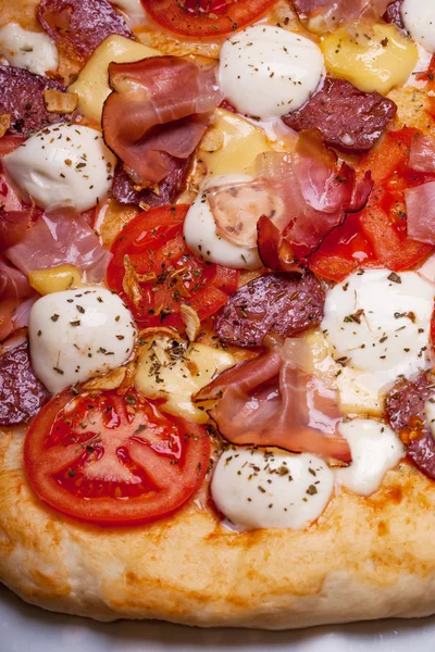 Pizza with salami, tomato and ham — Stock Photo, Image