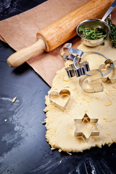 Cheese pastry dough with rolling pin on dark background — Stock Photo, Image