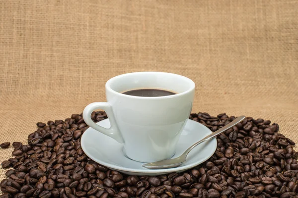 Cafea gustoasă cu boabe de cafea pe fundal — Fotografie, imagine de stoc