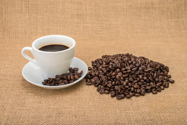 Café saboroso com grãos de café no fundo — Fotografia de Stock