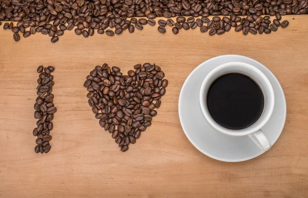 Leckerer Kaffee mit Kaffeebohnen im Hintergrund — Stockfoto