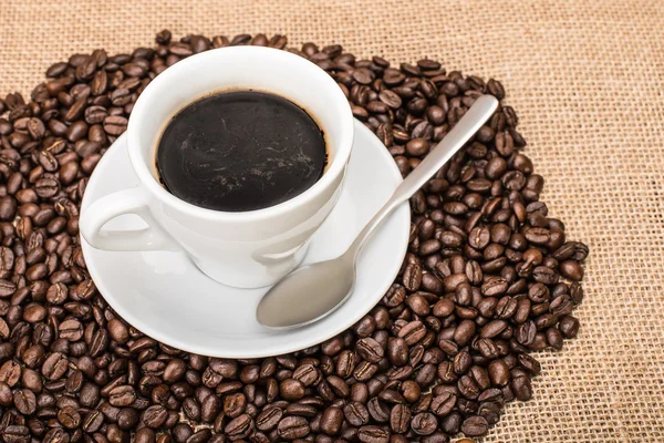 Tasty Coffee with coffee beans on background — Stockfoto