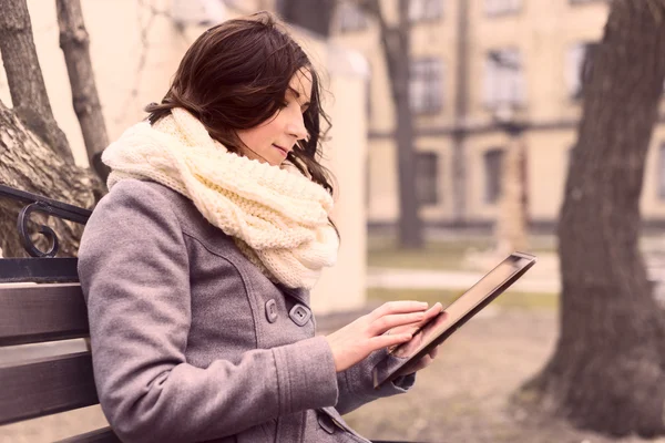 Young woman sitting with Tablet and reading — Stock Photo, Image