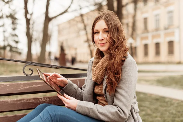 Young woman sitting with Tablet and reading — Stock Photo, Image