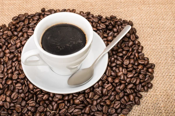 Café savoureux avec des grains de café sur le fond Photo De Stock