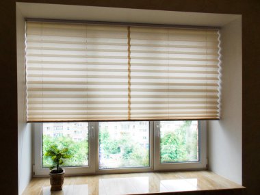 Pilili panjurlar XL Coulisse, bej rengi, 50mm 'lik iç taraftaki pencereye yakın çekim. Ev jaluzileri - modern alt üst gizlilik gölgeleri daire pencerelerinde yarı yükseltilmiş.