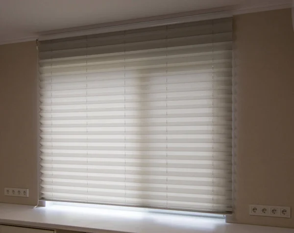 Pleated blinds XL Coulisse, white color, with 50mm fold close up in the window opening in the interior. Luxury sun protection and window decoration. Modern shades.