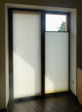 Özel bir evin balkon kapısında plili panjurlar var. Kablosuz pileli gözlük. Çağdaş yukarıdan aşağıya özel hücre gölgeleri daire penceresinde.