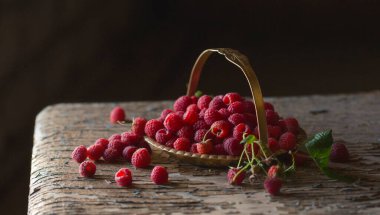 Yapraklı ahududu böğürtlenleri eski ahşap bir masada bakır antika bir tabakta kapanıyor. Ahududulu kırsal yaşam. Ağustos hasatı.