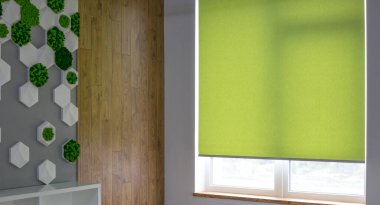 Paten perdeleri iç taraftaki pencereye yakın çekim yapıyor. Büyük pencereler için paten gözlüğü. Ofis için otomatik perdeler. Yeşil renk, tek renkli malzeme. Pencere kapakları.