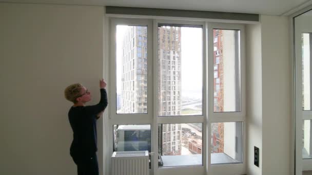 Girl Lowers Roller Shade Large Window Gray Fabric Window City — Stockvideo