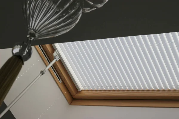 Pleated blinds on roof windows close up in the interior. Blinds for skylights. White color.