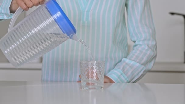 Mujer vierte agua en un vaso — Vídeos de Stock