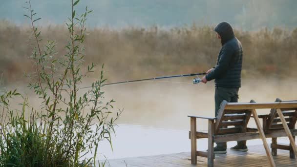 Рыбаку нравится хобби на берегу реки — стоковое видео