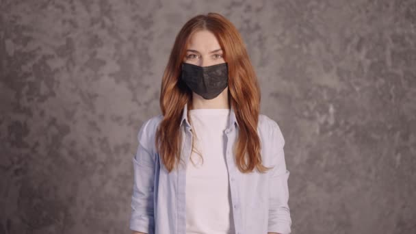Kızıl kadın tıbbi maske takıyor. — Stok video