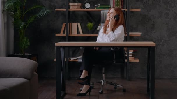 Red headed female using cell phone indoors — Vídeos de Stock