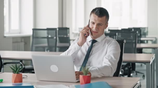 Portret ontevreden zakenman praten door mobiel kijken op display computer — Stockvideo