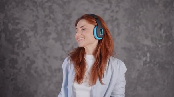 Face young red headed female with earphones dances — Video Stock