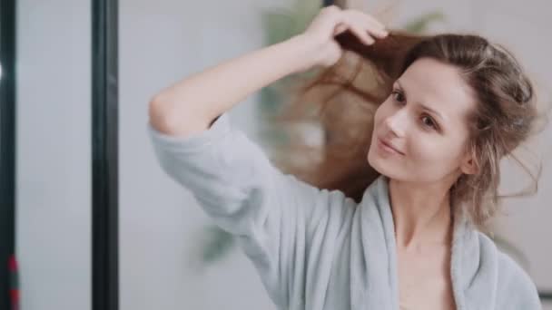 Female combing hair in the morning — Video