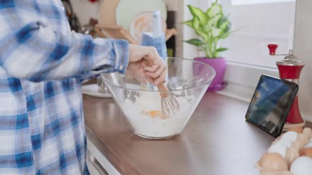 女人把鸡蛋和面粉混合在一起做面团烤慢动作自制面包或在厨房用窗口慢动作射击做糕点 — 图库视频影像