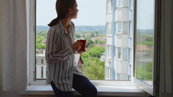 Woman Holding Cup Drinking Tea Sitting Windowsill Enjoy City View — Vídeo de Stock