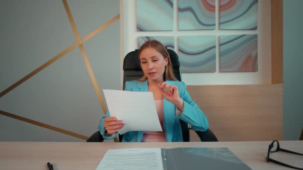 Κουρασμένη Επιχειρηματίας Φορώντας Μπλε Κοστούμι Κάθεται Ένα Γραφείο Ανάγνωση Των — Αρχείο Βίντεο