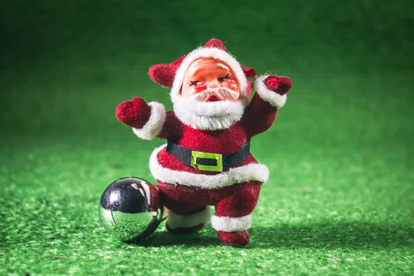 Weihnachtsmann mit silberner Kugel auf grünem Hintergrund. — Stockfoto