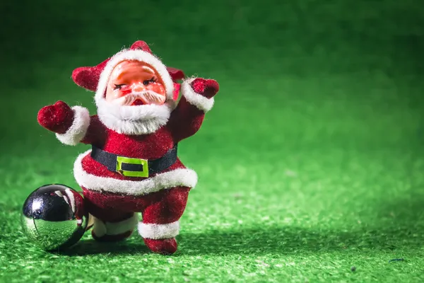 Weihnachtsmann mit silberner Kugel auf grünem Hintergrund. — Stockfoto