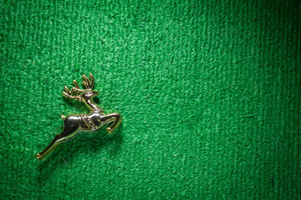 Golden raindeer jumping on green carpet. — Stock Photo, Image
