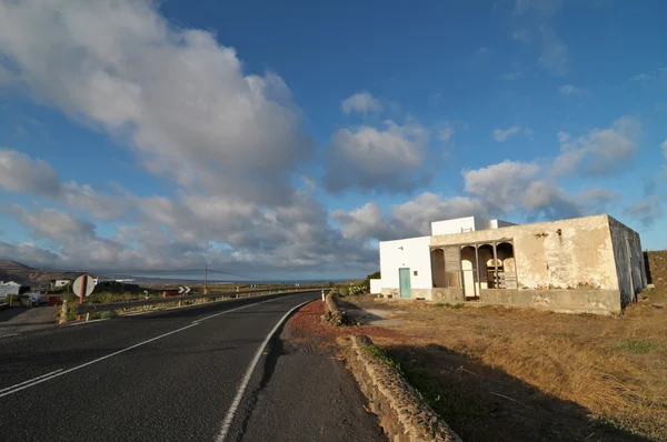 Edificio abbandonato nel deserto su un cielo nuvoloso — Foto Stock