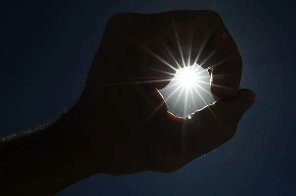 En hand fånga solstjärnorna på en blå bakgrund — Stockfoto