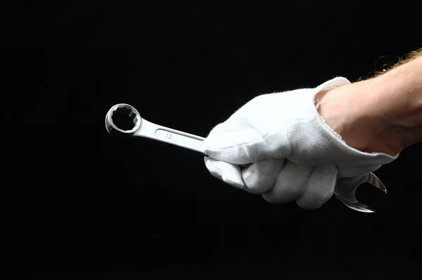 Eine Schlüsselschraube und eine Hand — Stockfoto