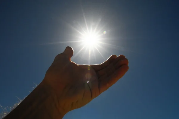 One Hand Catching the Sun Stars on a Blue Background — Stock Photo, Image