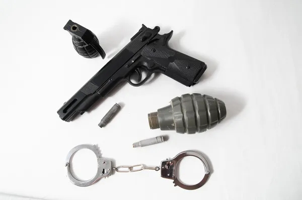 Granada balas pistola y esposas — Foto de Stock