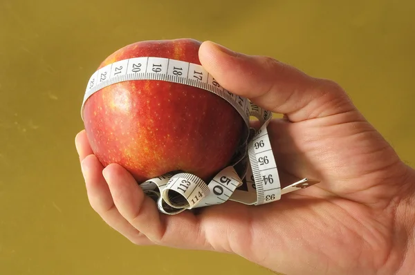 Dietní jablko a metr na ruce — Stock fotografie