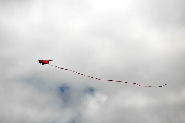 Een vlieger vliegen over een bewolkte hemel — Stockfoto