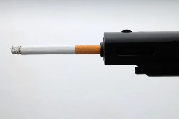 Cigarro e arma — Fotografia de Stock