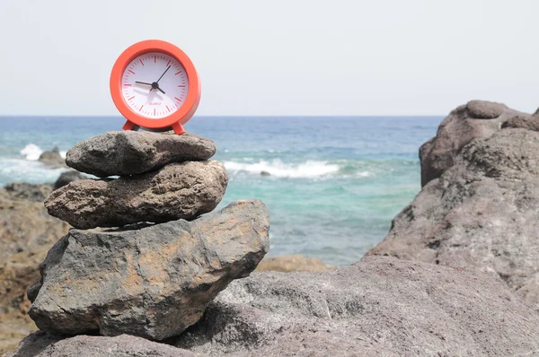 Rote Uhr in der Nähe des Ozeans — Stockfoto