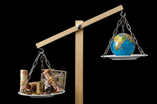 Jord og penge på en Two Pan Balance - Stock-foto