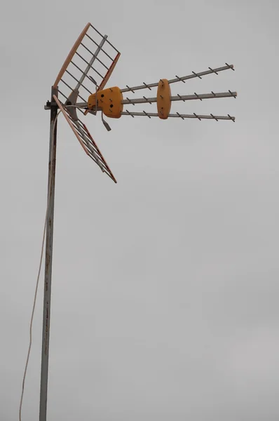 Antenner på ett tak över mulen himmel — Stockfoto