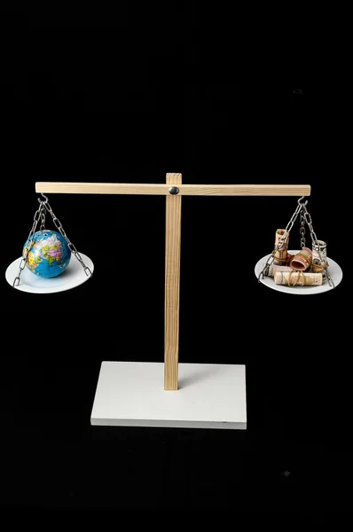 地球和金钱在两盘平衡中的作用 — 图库照片