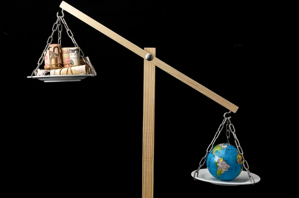 Earth and Money on a Two Pan Balance — Stock Photo, Image