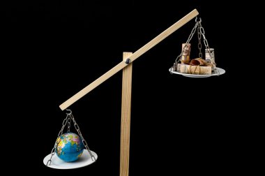 Earth and Money on a Two Pan Balance clipart