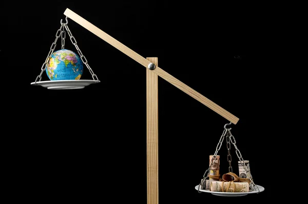 Earth and Money on a Two Pan Balance — Stock Photo, Image