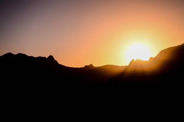 山の後ろに沈むオレンジ色の太陽 — ストック写真