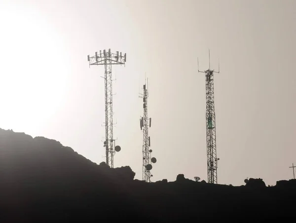 Een Aantal Silhouetted Antennes Top Van Een Heuvel — Stockfoto