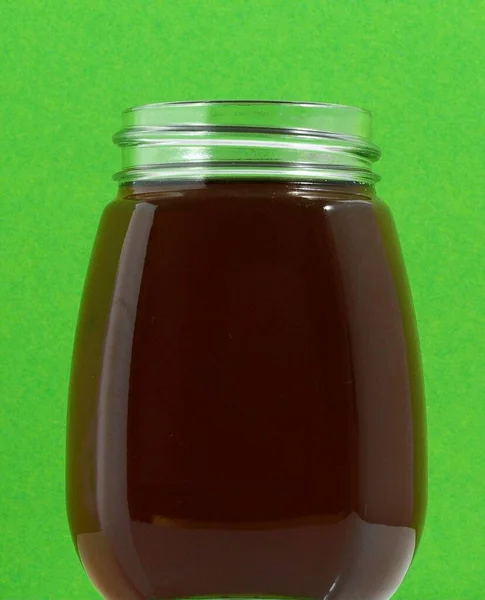 Ein Volles Honigglas Auf Farbigem Hintergrund — Stockfoto