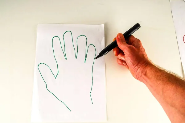 hand drawing a hand on a white paper